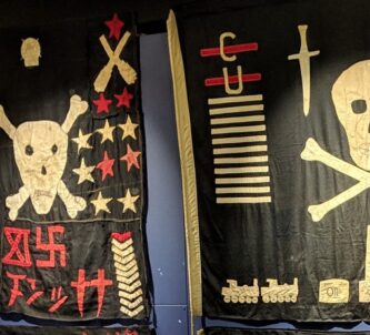 Two Black flags with skull & crossbones and other symbols