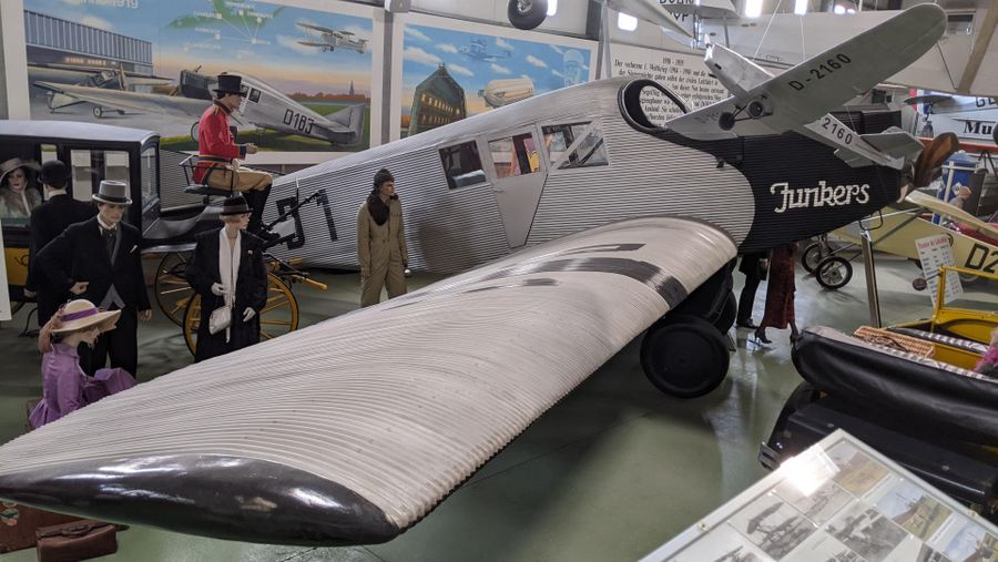 Small single-engine passenger plane with a silver body & wings made of corrugated aluminium