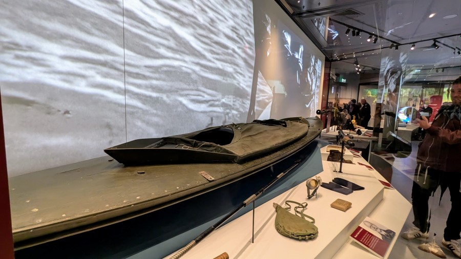 A dark grey kayak with other items on display