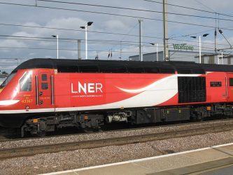 A red high speed diesel locomotive with LNER logo stands alongside a platform