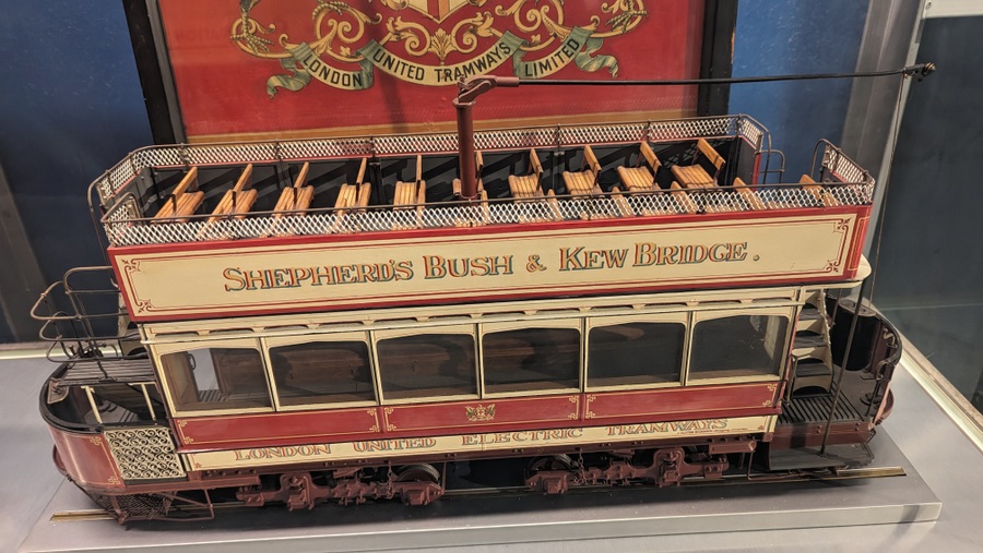 Model of an open top double-decker tram with a trolley pole to collect electric power from the overhead power lines