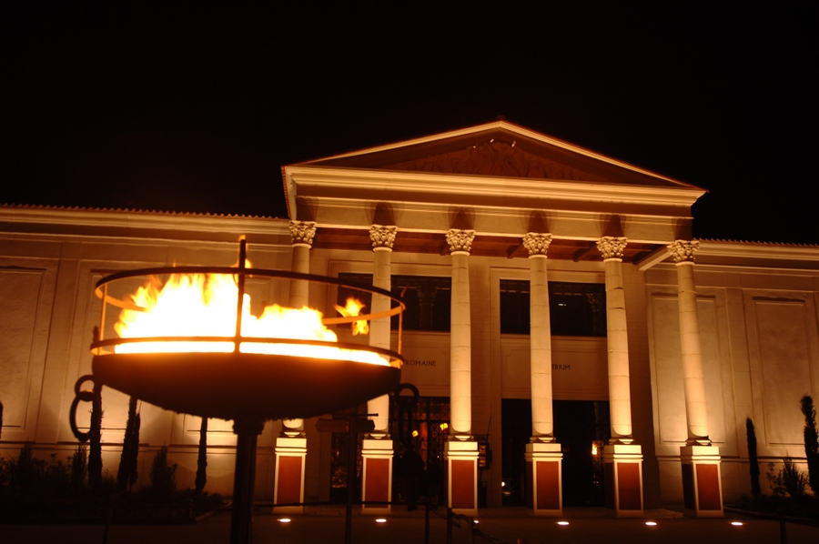 Grand portico entrance to a Roman villa by night, with a brazier burning in the foreground