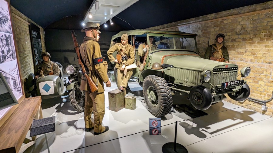 A group of Allied soldiers (mannequins) stand next to a Laffly v15T military truck. Next to them is a motorcycle-sidecar