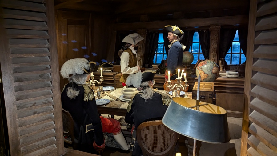 Four officers around a table in the Captain's cabin