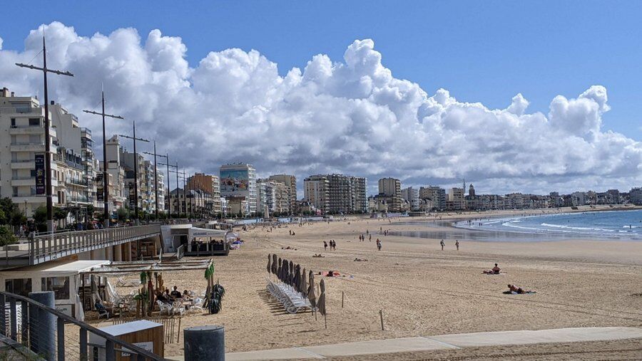 Blocks of apartments curve around a large promenade and beach