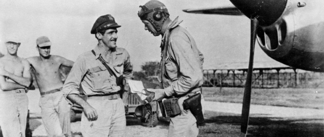 Charles A. Lindbergh talking with Maj. Thomas B. McGuire in front of a P38 with ground crew in the background.