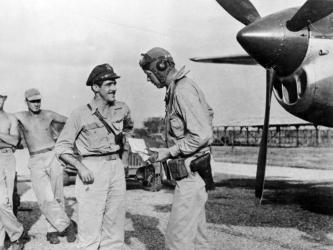 Charles A. Lindbergh talking with Maj. Thomas B. McGuire in front of a P38 with ground crew in the background.