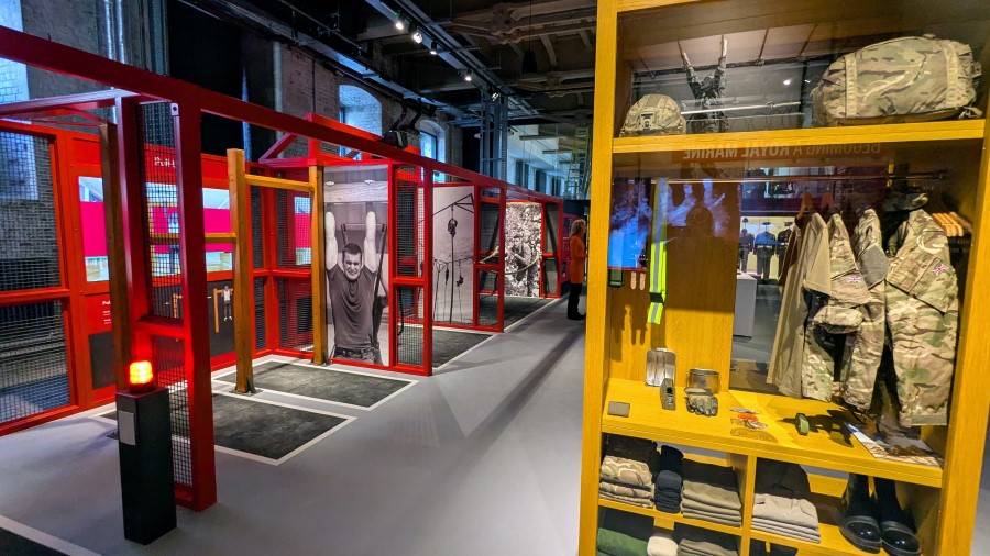 a row of traing stalls and in the foreground shelves with folded Royal Marine clothes