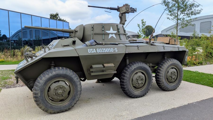 A six-wheeled armoured car with a 37mm canon in the turret and a .50 cal machine gun on a mount