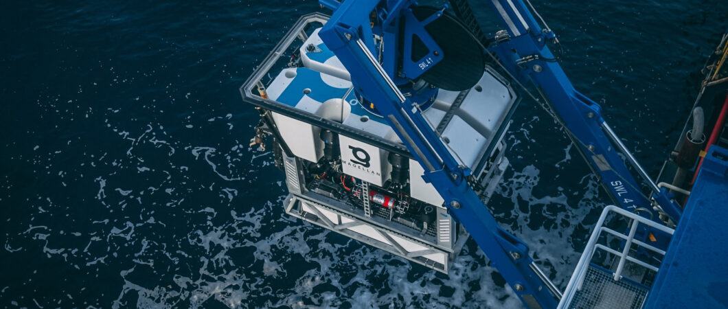 A box shaped ROV being lowered into the sea