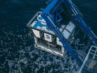 A box shaped ROV being lowered into the sea