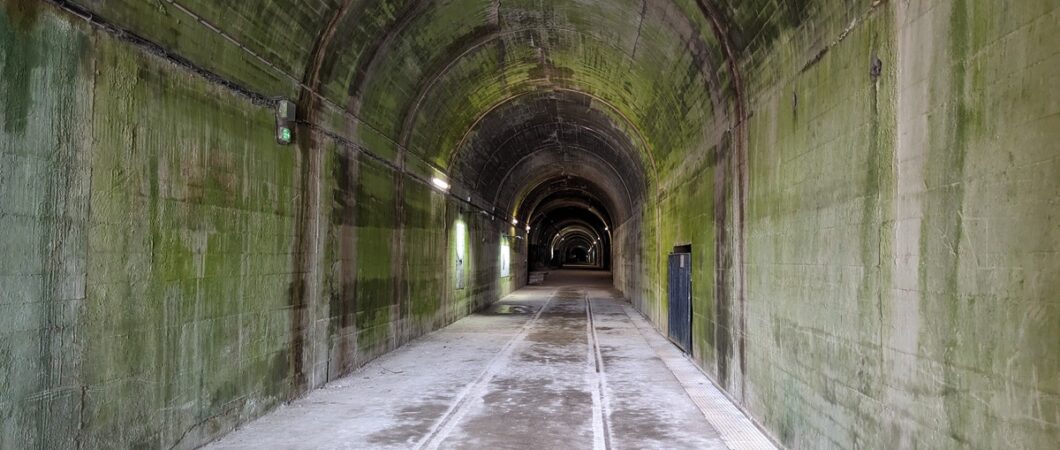 A large grey concrete tunnel disappears into the distance