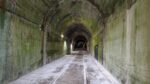 A large grey concrete tunnel disappears into the distance