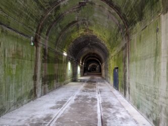 A large grey concrete tunnel disappears into the distance