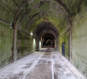 A large grey concrete tunnel disappears into the distance