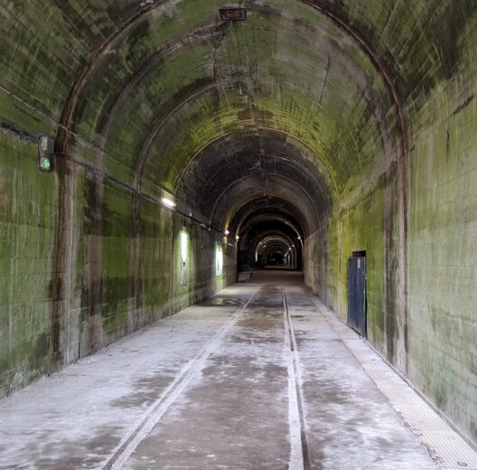 A large grey concrete tunnel disappears into the distance