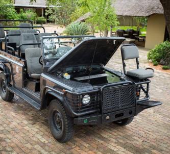 A green Landrover safari viewing vehicle with its bonnet open displaying the battery pack