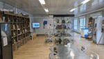 Inside the single storey reception with bookshop shelves and cafe tables & chairs