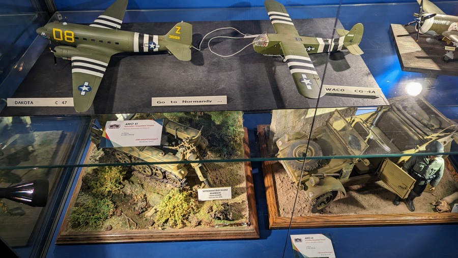 Glass case with models of aircraft and vehicles