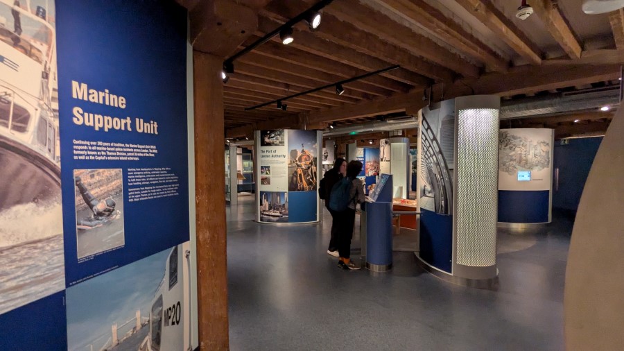 Visitors looking at info boards in a gallery at the London Museum, Docklands