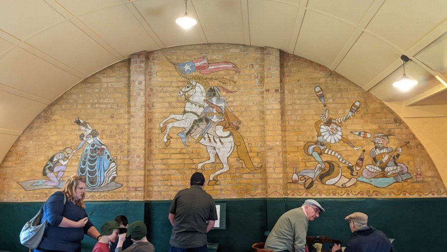 Visitors in the lounge with the brick wall and murals behind