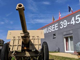 A 105mm howitzer stands guard outside the Musee 39-45 on a bright day