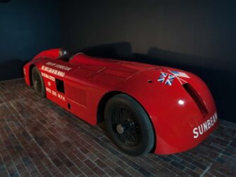 Long sleek open-cockpit vintage racing car in bright red