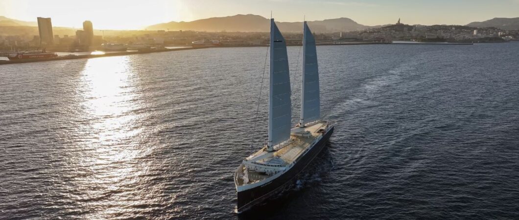Cargo ship with two sails sailing just of the south coast of France in evening sunlight