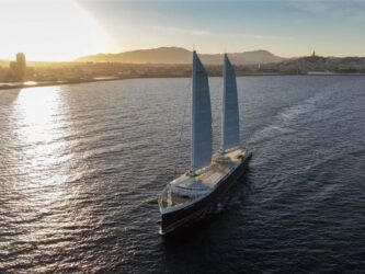 Cargo ship with two sails sailing just of the south coast of France in evening sunlight