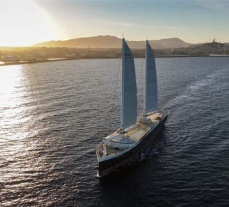 Cargo ship with two sails sailing just of the south coast of France in evening sunlight