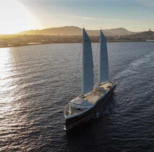 Cargo ship with two sails sailing just of the south coast of France in evening sunlight