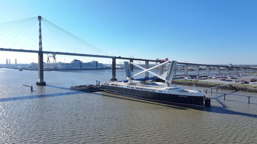 Neoliner Origin tied up alongside with her masts lowered. Behind her are the huge St Nazaire bridge and the Chantiers de l'Atlantique shipyard