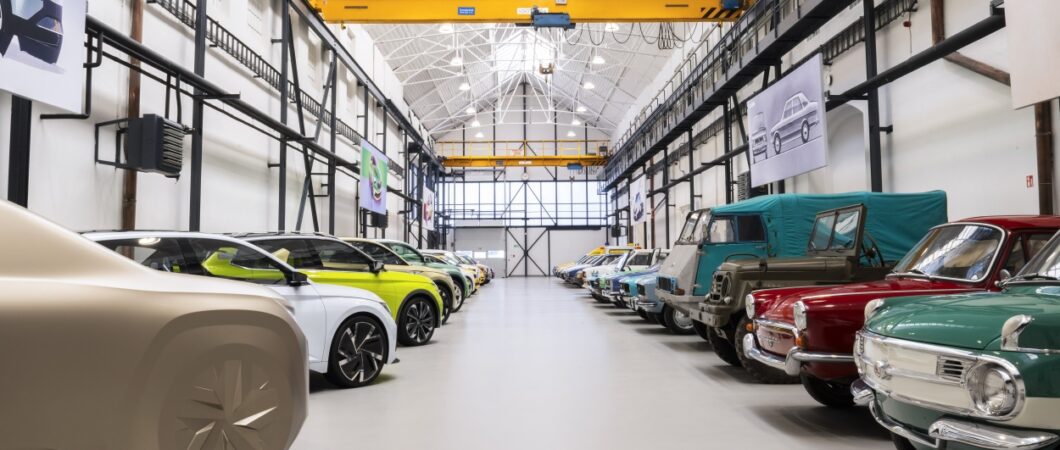 A row of cars down each side of a whitewashed factory hall