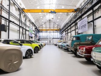 A row of cars down each side of a whitewashed factory hall
