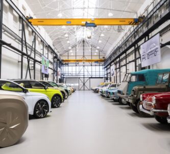 A row of cars down each side of a whitewashed factory hall