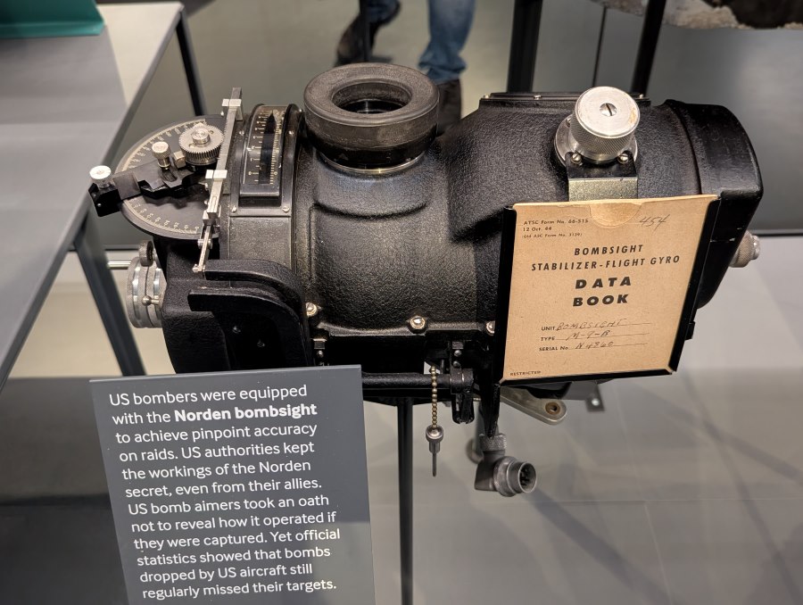 Norden bombsight - a black cylinder shaped instrument with an eyepiece and multiple dials