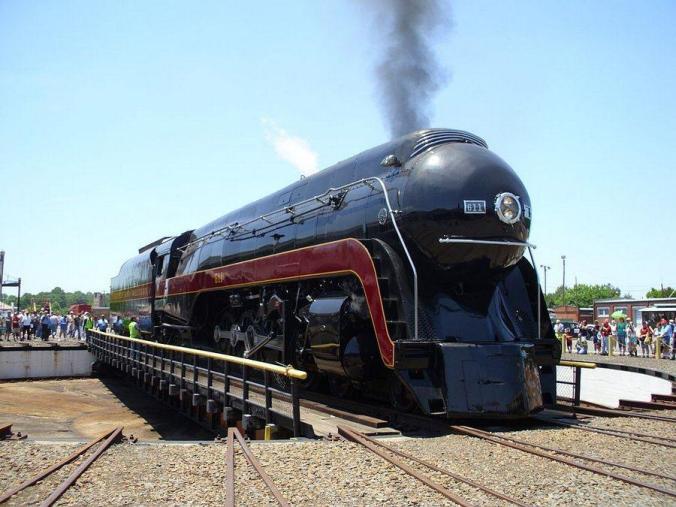 Glistening black Norfolk & Western locomotive with a maroon stripe, on a turntable