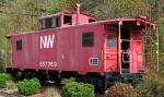 A red-painted but faded Norfolk & Western Railways caboose (guard's wagon) on a siding.
