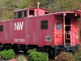 A red-painted but faded Norfolk & Western Railways caboose (guard's wagon) on a siding.