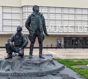 Statue of two airmen looking skyward with the Air & Space Museum entrance in the background