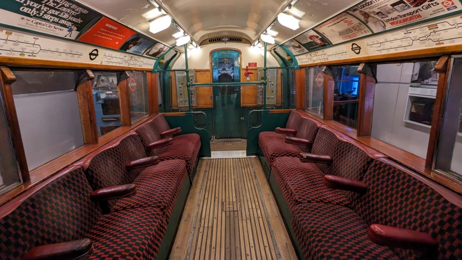 Old tube carriage interior with wooden grooved floor and dark moquette seats