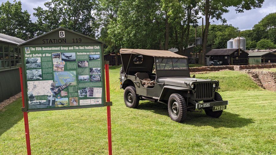 A noticeboard about the site and a US Army jeep parked nearby