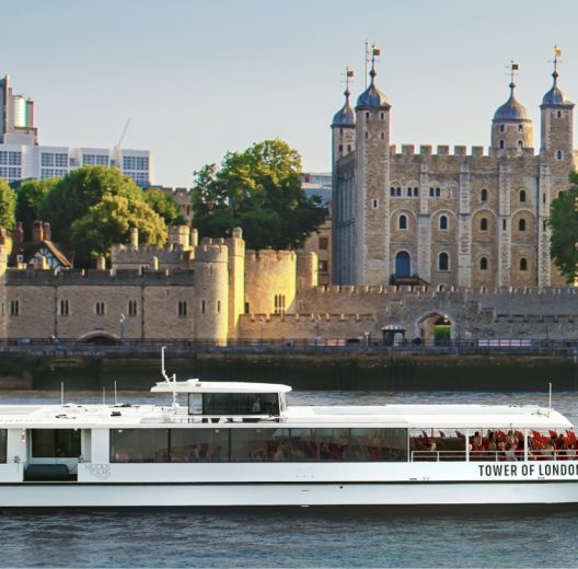 White Tower of London River Tour boat passes the Tower of London