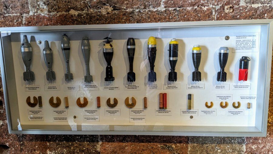 A collection of mortar shells displayed in a wall cabinet