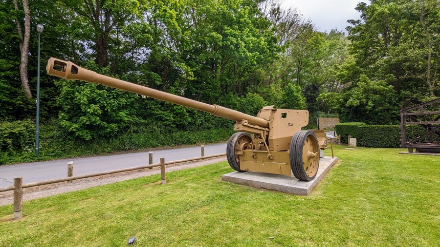 Large towed artillery gun, with a long thin barrel, painted in desert brown