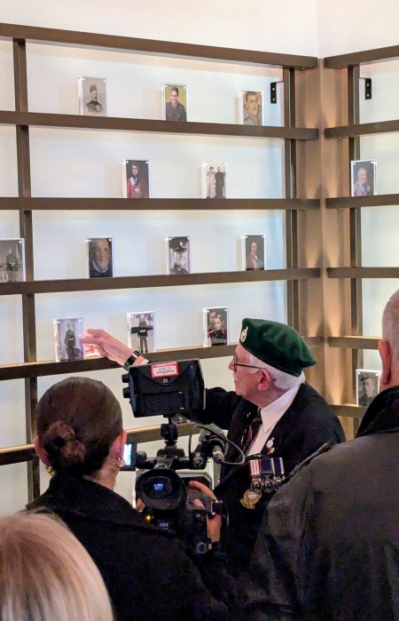 RM veteran Peter Othen places a memorial picture on a shelf surrounded by colleagues and press