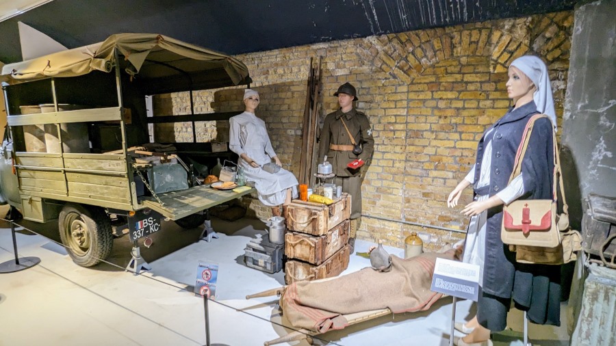 Dynamo Museum diorama: Two WW2 nurses and an orderly (mannequins) gathered at the back of a Peugeot 202 light truck with their equipment and medical supplies