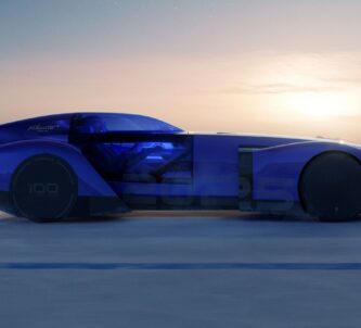 Sleek blue car with a sunset behind it