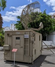 Small green shipping container sized box with a radar dish on top