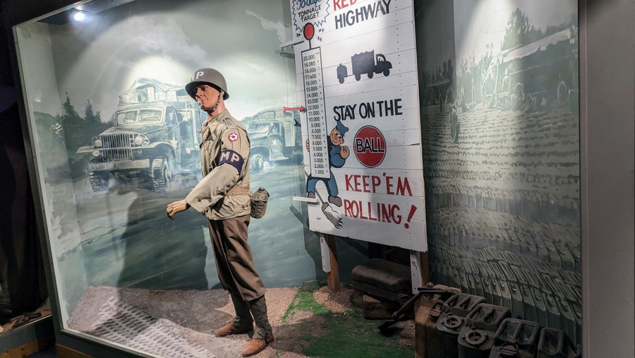 Diorama of a Military Policeman waving on the Red Ball trucks by a roadsign